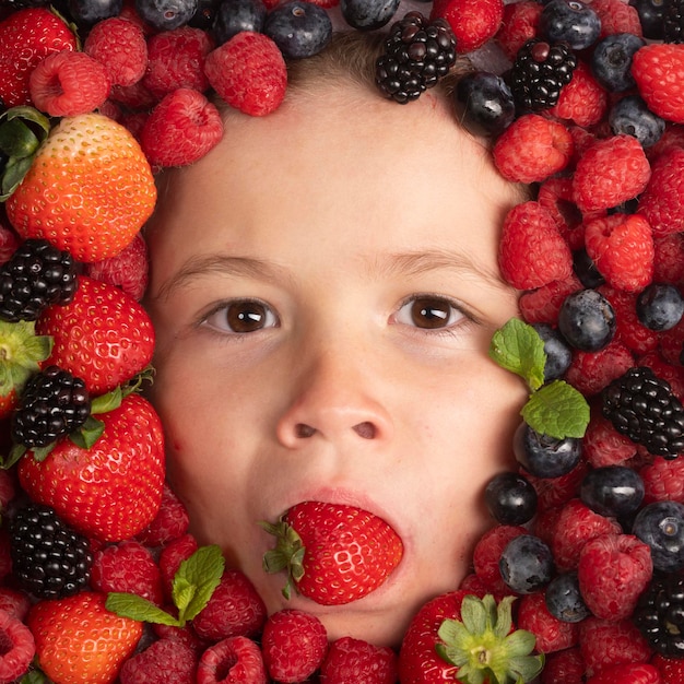 Strawberry blueberry raspberry blackberry background on child face healthy kids eating the kids face