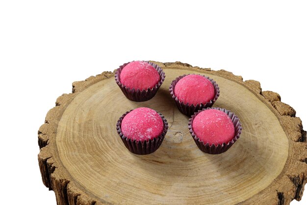 Strawberry Brazilian fudge balls Bicho de Pe on tree trunk disheswhite background