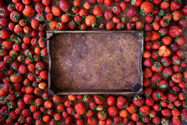 Photo strawberry on brown background, top view. frame made of fresh strawberry and wooden box