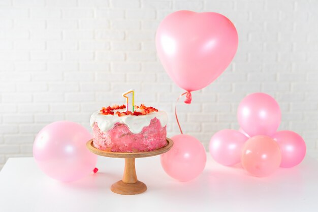 Strawberry cake and pink ballons on white background