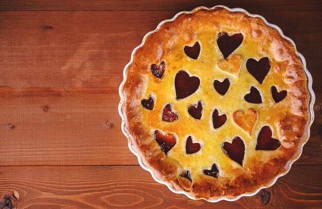 Strawberry cake for valentine's day with hearts on a wooden background