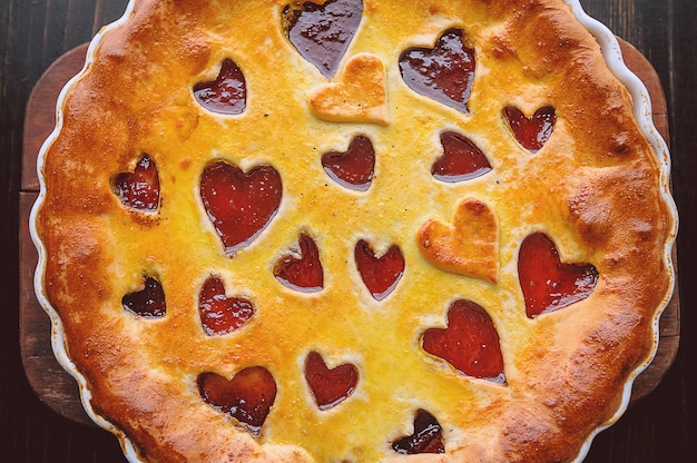 Strawberry cake for Valentine's Day with hearts on a wooden table