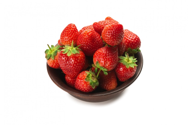 Strawberry in ceramic brown bowl. Fresh berries macro. Isolated on white.