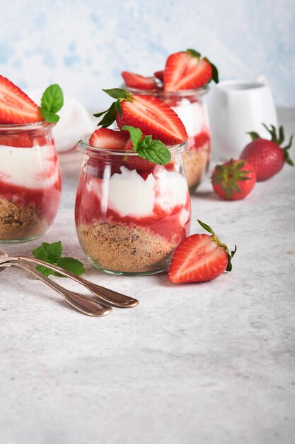 Strawberry Cheesecake Cheesecake of trifle met aardbei in glas op oude grijze betonnen achtergrond tabelachtergrond Cheesecake zonder bakken Dessert New York kopie ruimte Voedsel achtergrond