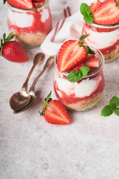 Strawberry Cheesecake Cheesecake of trifle met aardbei in glas op oude grijze betonnen achtergrond tabelachtergrond Cheesecake zonder bakken Dessert New York kopie ruimte Voedsel achtergrond