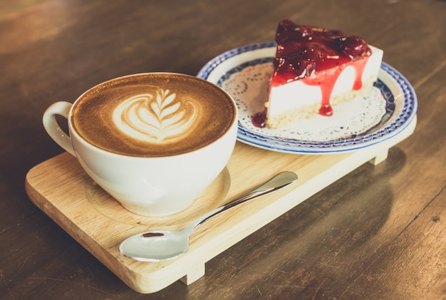 Strawberry Cheesecake en latte koffie op houten tafel