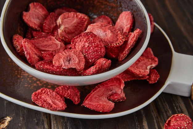 Strawberry chips are stacked in ceramic dish Hundredpercent natural freezedried strawberries