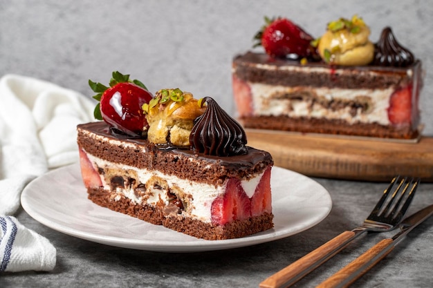 Strawberry and chocolate cake on a dark background Slice of layered chocolate cake Bakery cake products close up