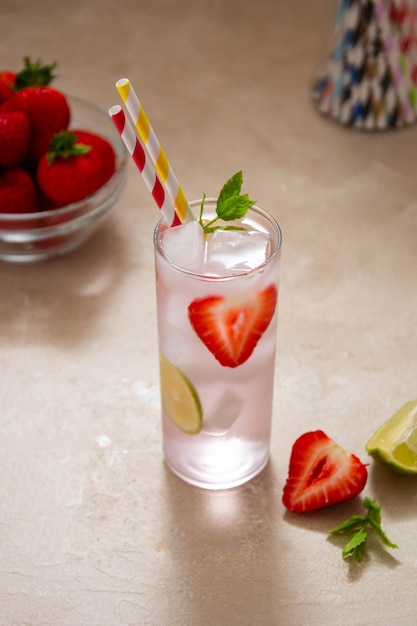 Strawberry cold drink with fresh berry, lime and mint. Summer cold drink with papper straw