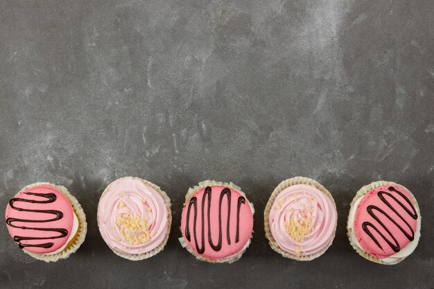 Cupcakes alla fragola su sfondo di pietra grigia vista dall'alto