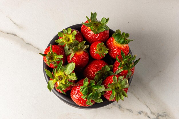 Strawberry dessert served in a jar on a wooden board and marble background fresh fruit