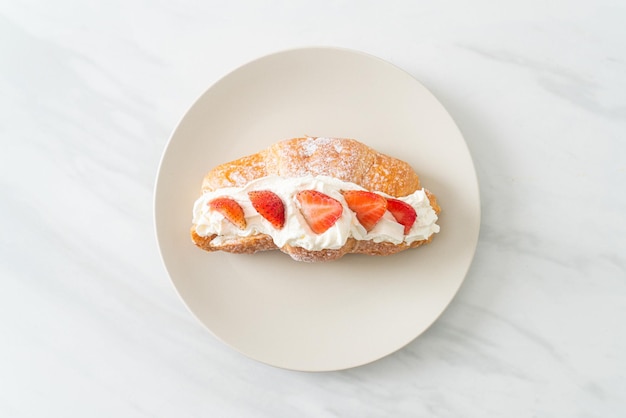 strawberry and fresh cream croissant on plate