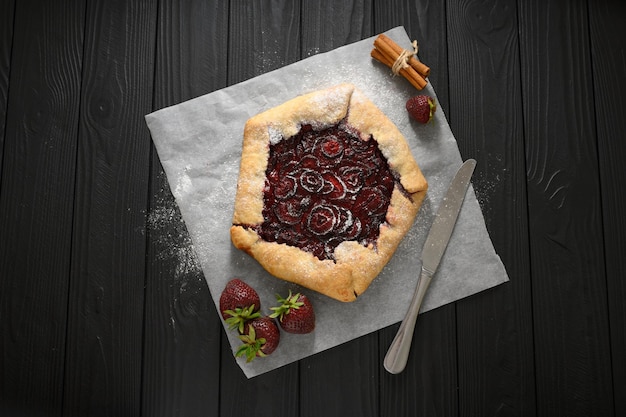 Strawberry galette on dark wooden background Homemade