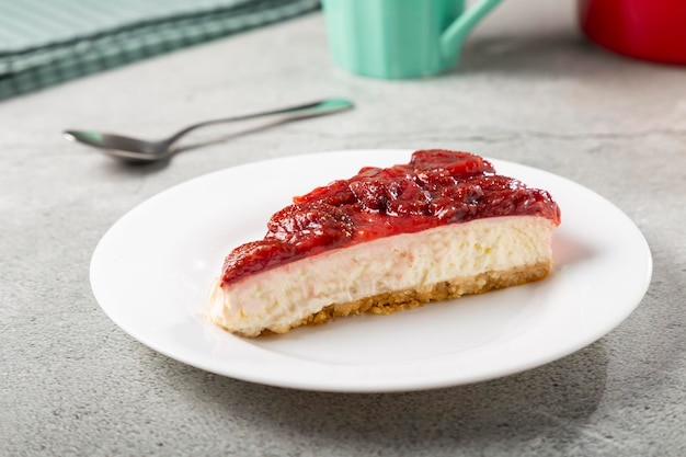 Strawberry glazed cheesecake on white dinnerware on the table