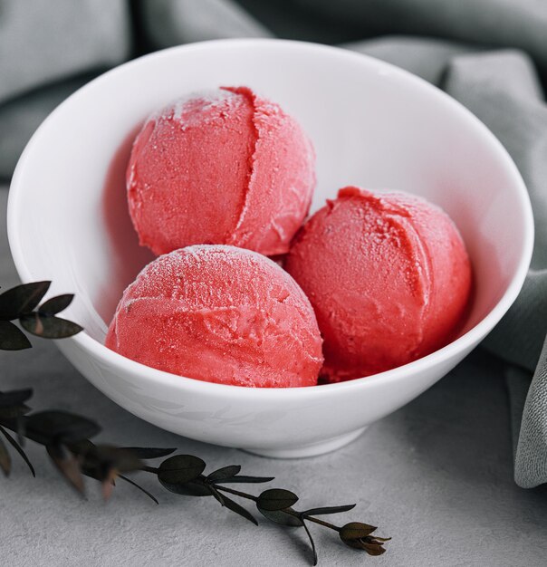 Strawberry ice cream balls in a white bowl
