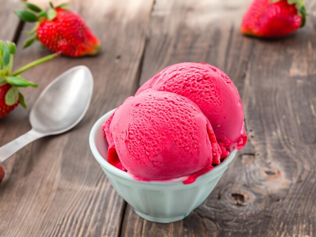 Strawberry ice cream in bowl on country table