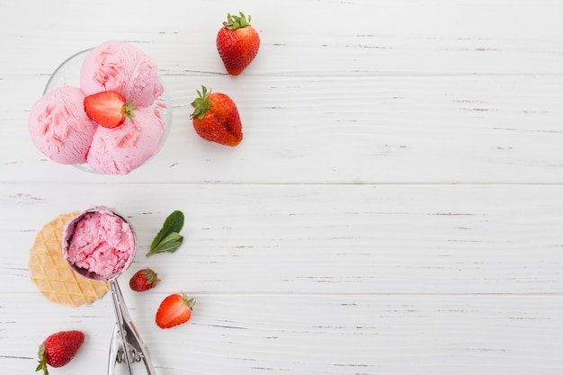 Foto gelato alla fragola in ciotola sulla superficie in legno