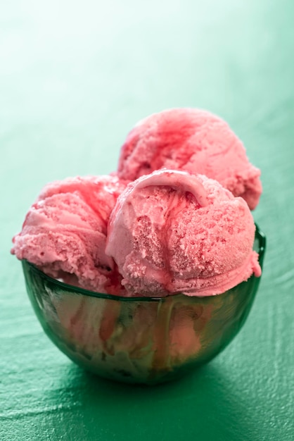 녹색 그릇에 딸기 아이스크림 국자 딸기 시럽을 곁들인 홈메이드 아이스크림