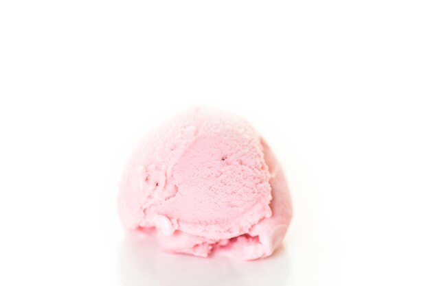 Strawberry ice cream scoop on a white background.