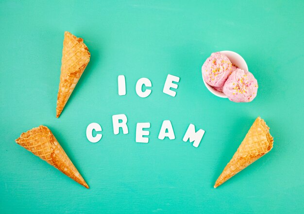 Strawberry ice cream  scoops in white bowl with topping on aquamarine background