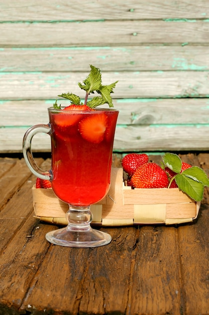 Strawberry juice on the old wooden background rustic style of cooking at home