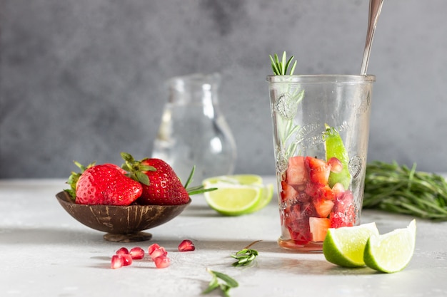 Strawberry lemonade and ingredients (strawberry, pomegranate, rosemary and lime). 