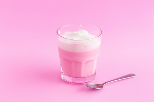 Photo strawberry milk shake from the glass on pink background