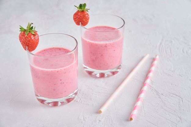 Strawberry milk shake in glass with straw and fresh berries