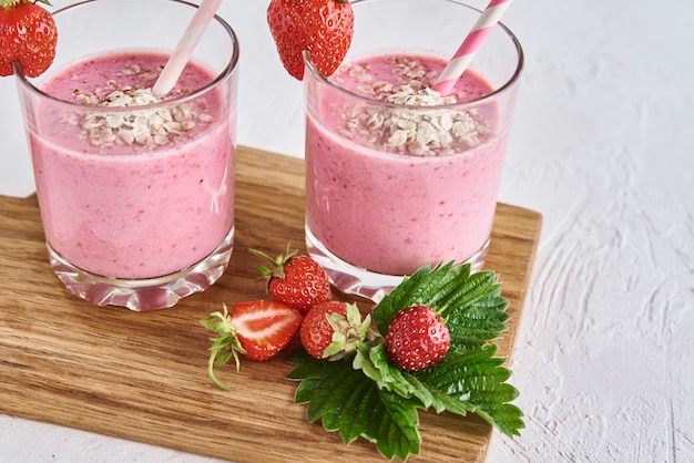 Strawberry milk shake in glass with straw and fresh berries