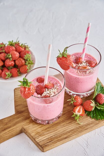 Strawberry milk smoothie in glasses with straws