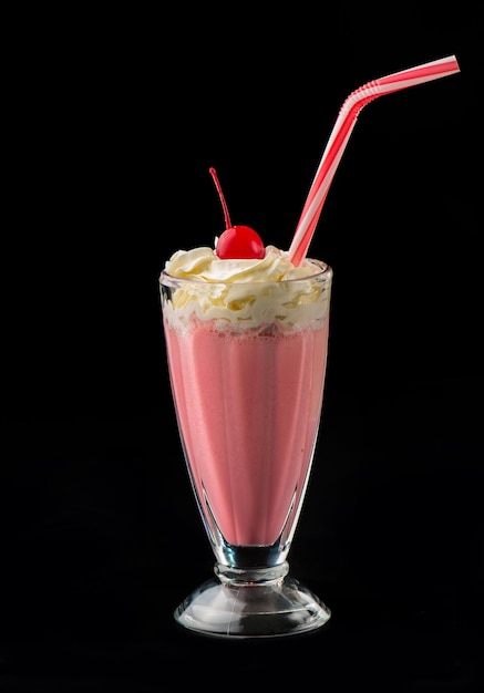 Strawberry milkshake and cherry isolated on black background