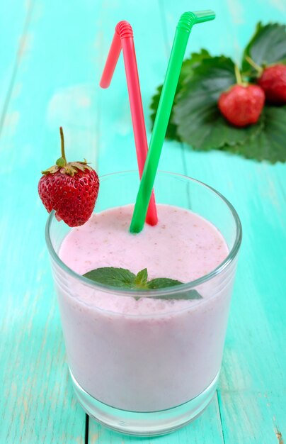 Frappè alla fragola in un bicchiere con foglie verdi