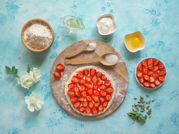 Torta alle fragole. ingredienti per cuocere una torta di fragole su un tavolo da cucina turchese.