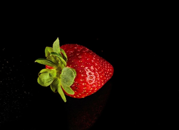 Strawberry rest on a black surface a vibrant product from natures bounty