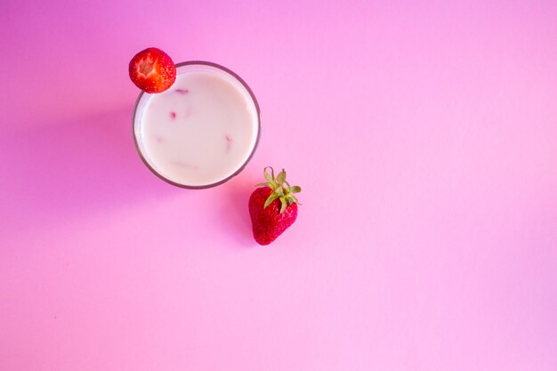Strawberry smoothie in a glass on pink.