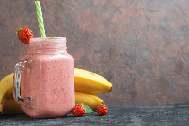 Strawberry smoothie on stone background