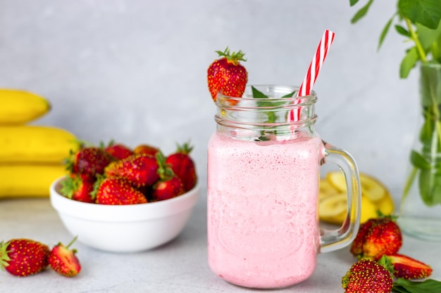 Strawberry smoothie Vegan smoothie or milkshake made from strawberry banana and mint on a gray background