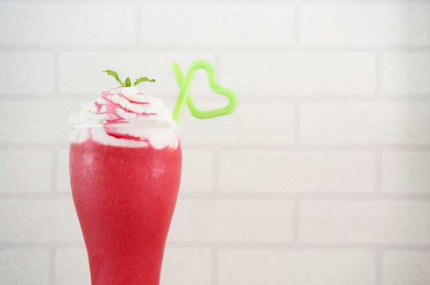 Photo strawberry smoothie on white bricks background.