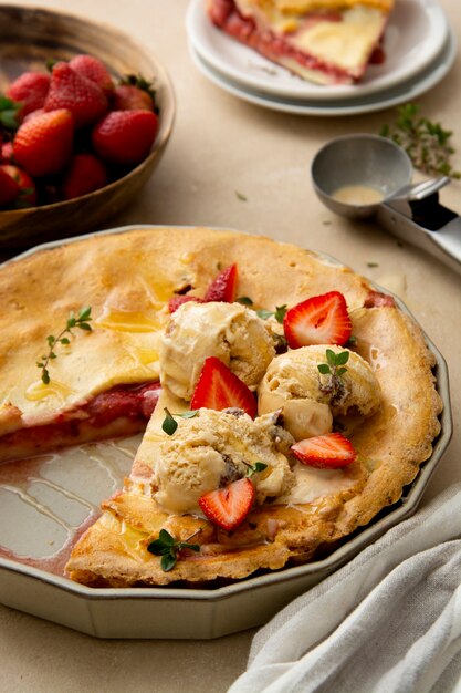 Strawberry tart, homemade pie filled with fresh strawberries, served with ice cream scoops, top view. Summer foods.