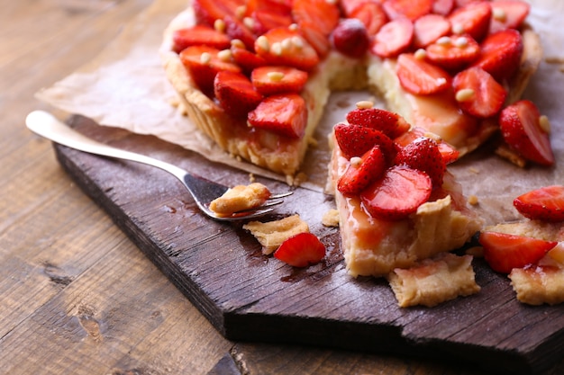 Strawberry tart on wooden tray, on rustic wooden table