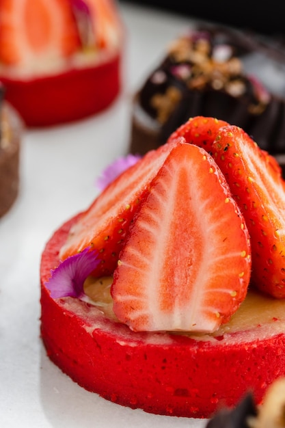 Photo strawberry tarts and chocolate tarts decorated with dark chocolate ganache background composition