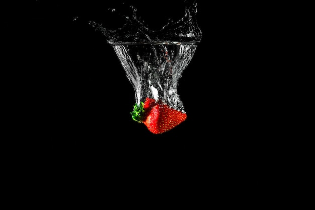 Fragola in acqua con sfondo nero