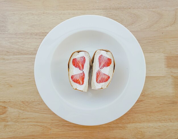 A strawberry whipped cream sandwich in a white plate