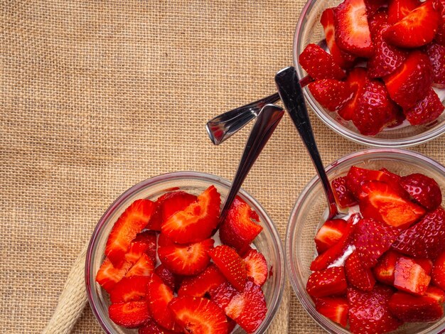 Strawberry with chantilly in glass bowls on sackcloth background