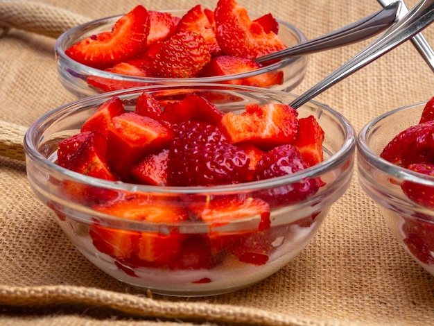 Strawberry with chantilly in glass bowls on sackcloth background