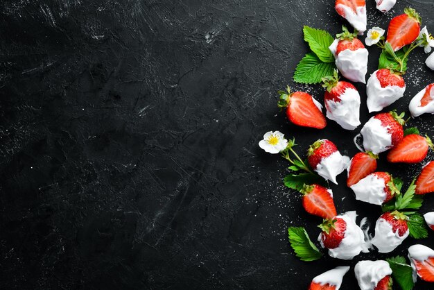 Strawberry with cream on a black stone background