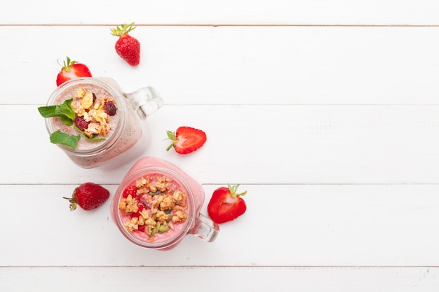 Strawberry with yogurt on white rustic wooden . Cream dessert