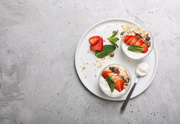 The strawberry in the yogurt. Glass bowls with cream and strawberries. Top view with copy space