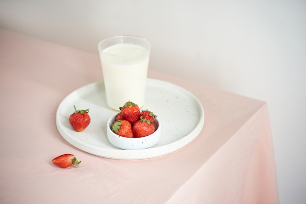 Strawberry and yogurt on pink background