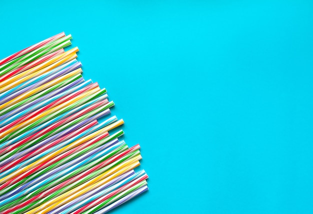 Straws for multicolored juice on a cyan background